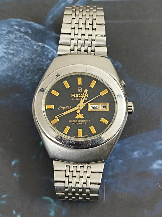 Ricoh Automatic Day Date Vintage Watch with a Black Dial and Golden Details