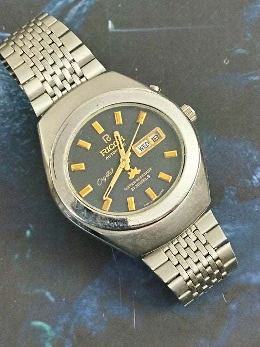 Ricoh Automatic Day Date Vintage Watch with a Black Dial and Golden Details